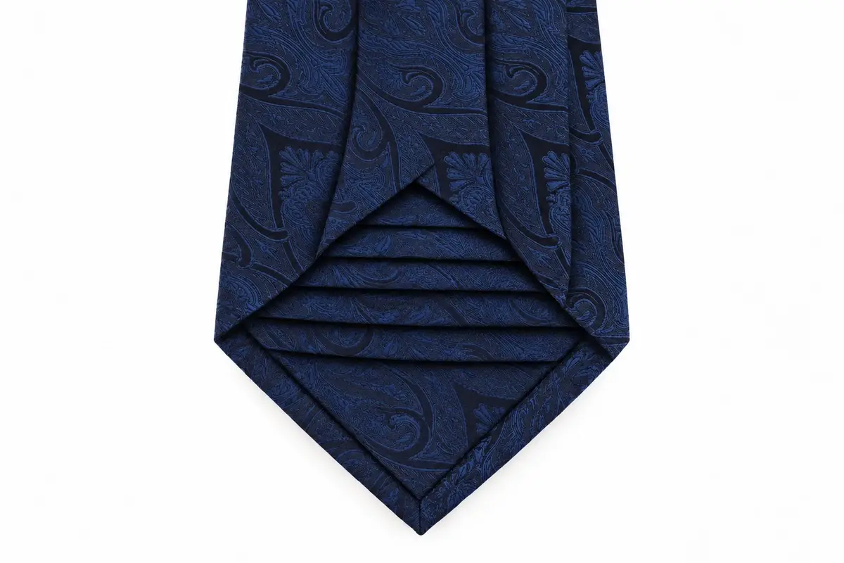 Open navy paisley tie blade showing the layered seven-fold silk construction.