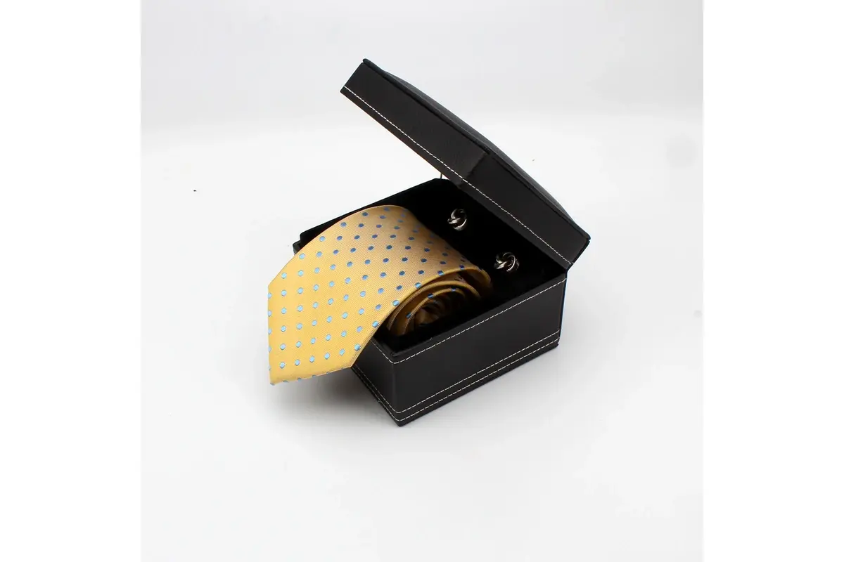 Yellow patterned tie presented in an open black gift box.