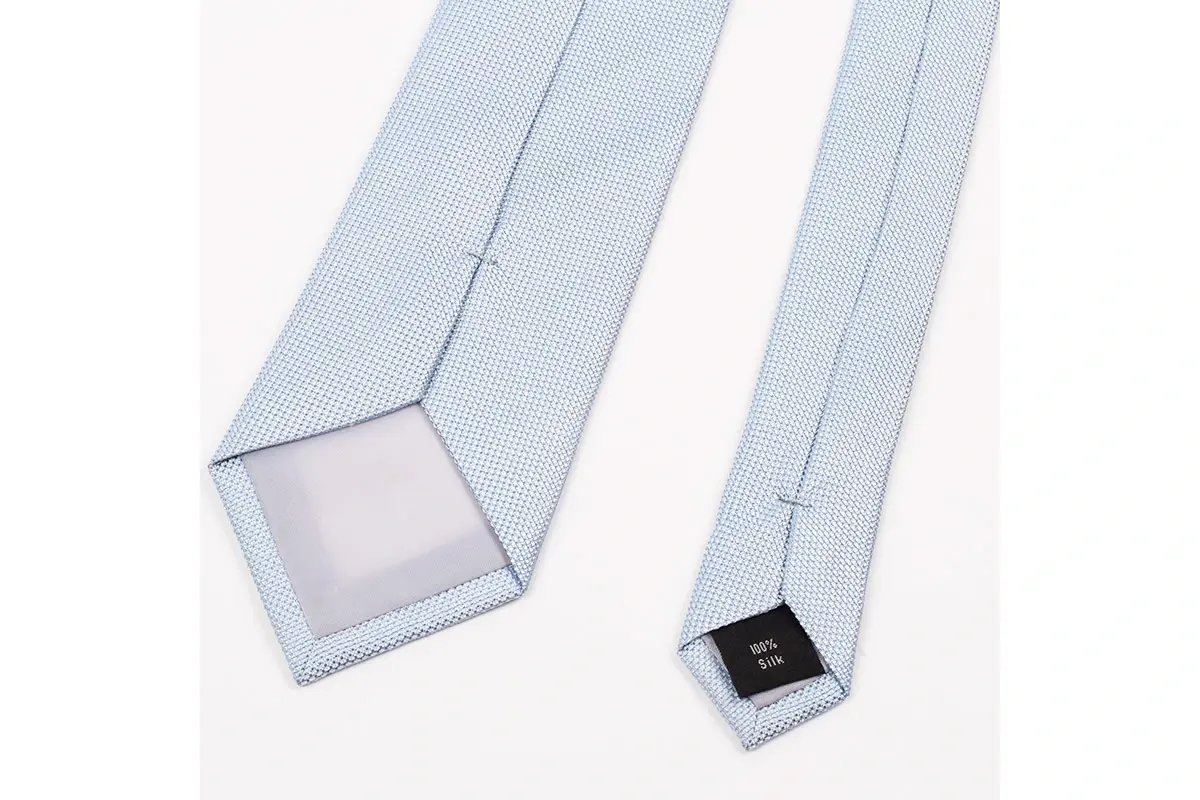 Pale blue tie reverse showing the center seam, tipping and silk label.