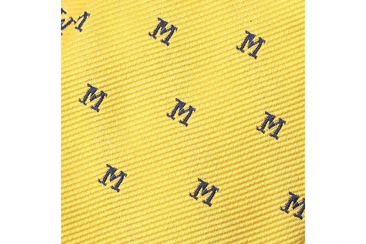 Close-up of dark letter motifs woven into yellow ribbed fabric.