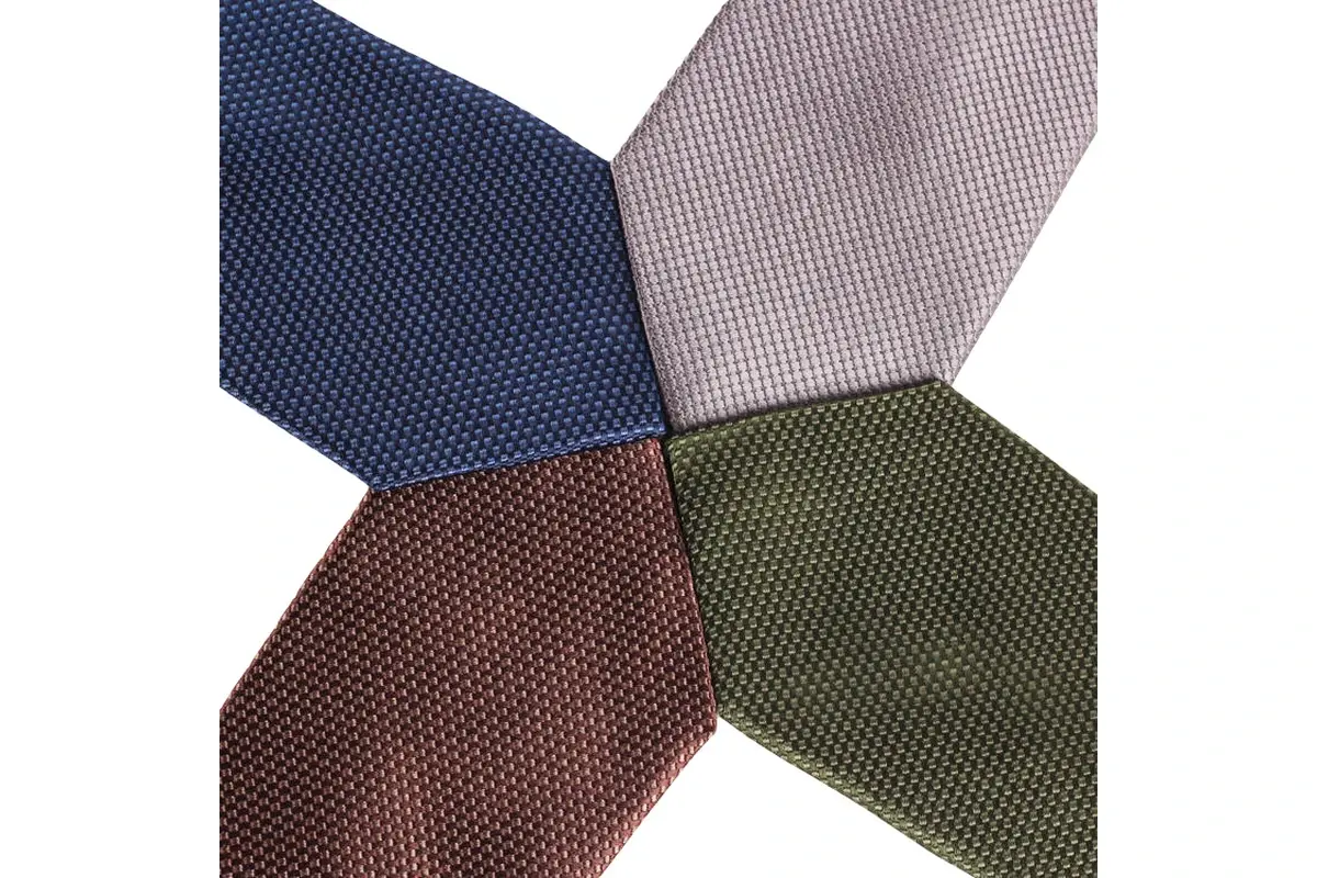 Four textured tie tips in navy, pale gray, brown and olive green.