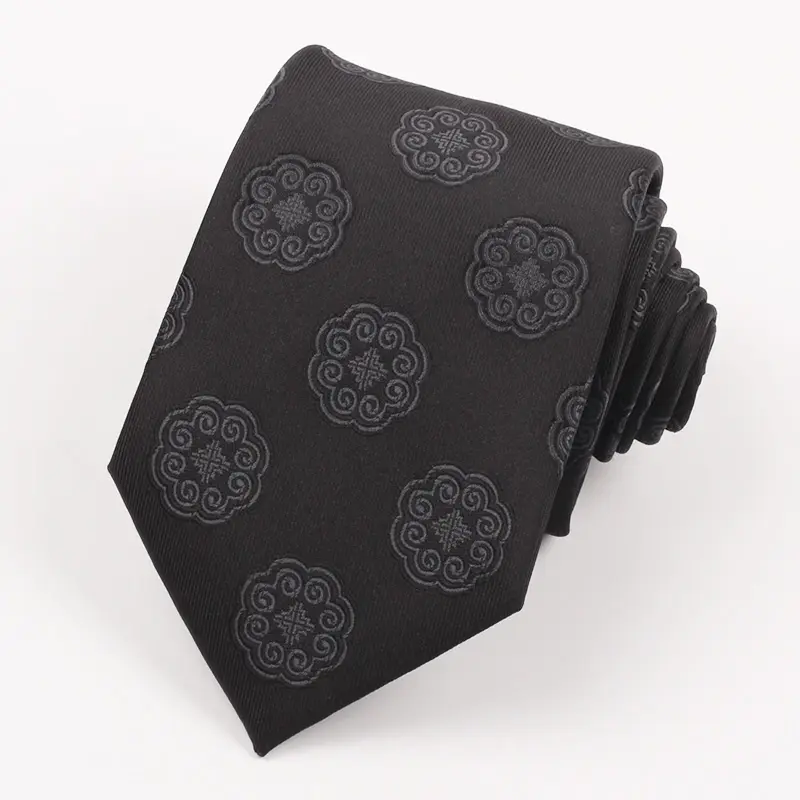 Rolled black tie with repeated tonal circular emblems.