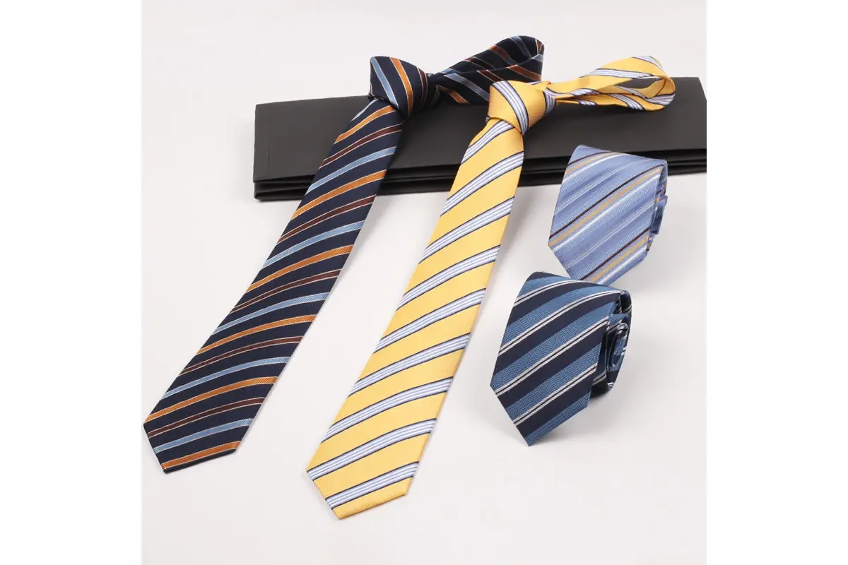 Four striped ties in navy, yellow and light blue, arranged knotted and rolled.