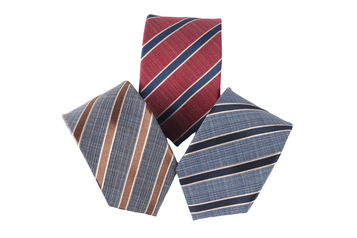 Three rolled burgundy, gray and blue ties with contrast diagonal stripes.