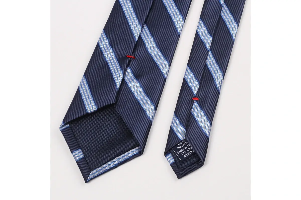 Navy striped tie reverse with stripe alignment at center seam, red stitches.