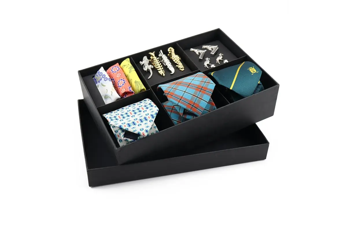 Open black presentation box with separate compartments for ties and accessories.