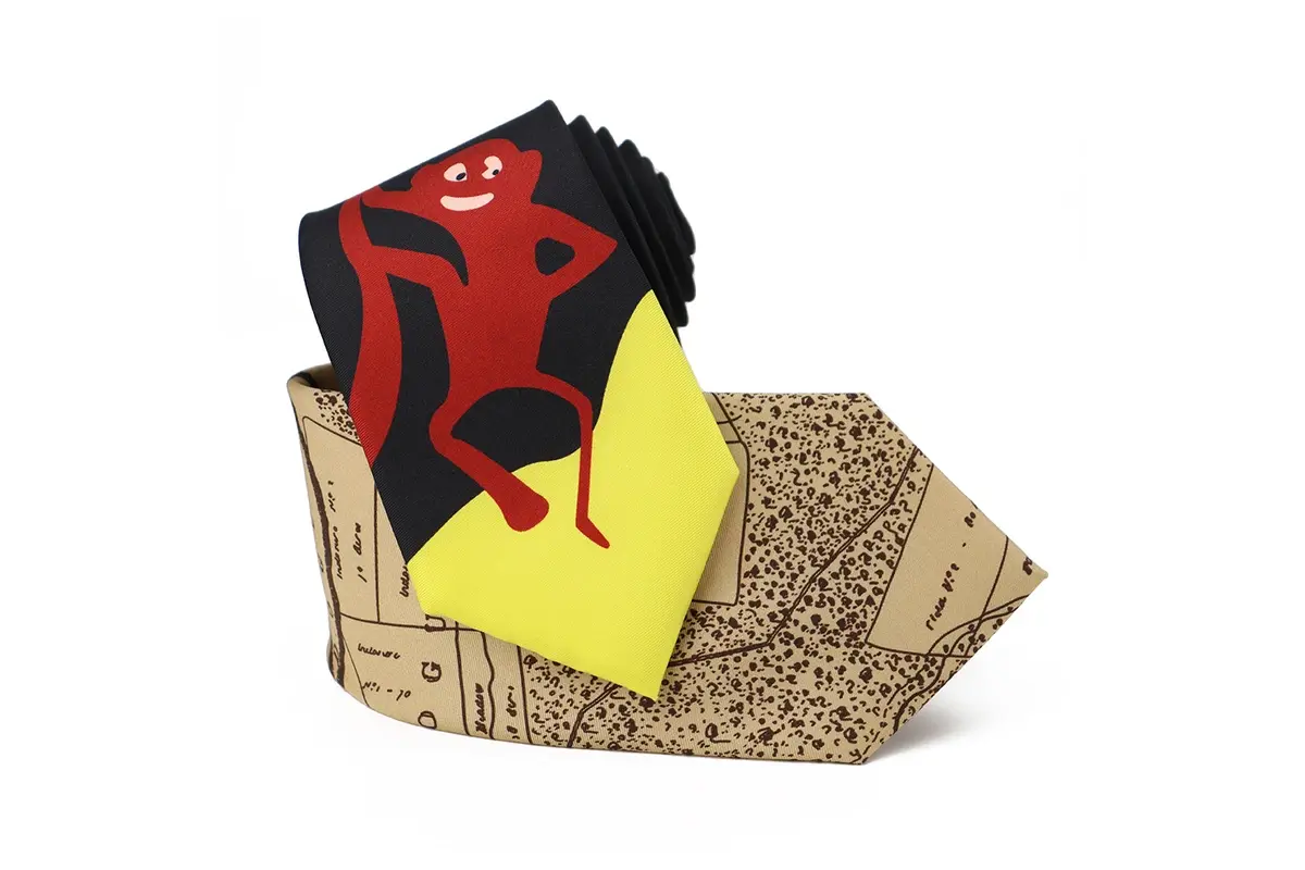 Two ties with large red character artwork and tan illustrated pattern on blades.