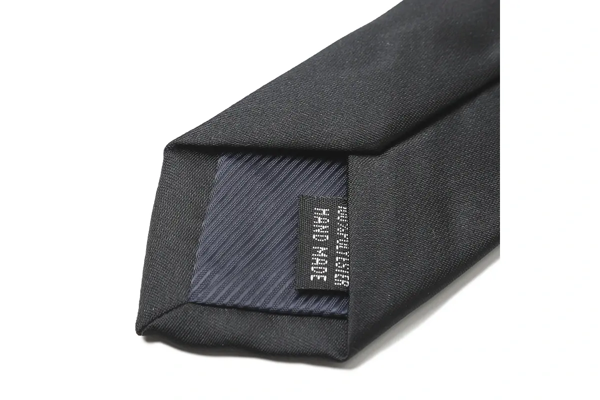 Black tie reverse with a small sewn information label and dark tipping.