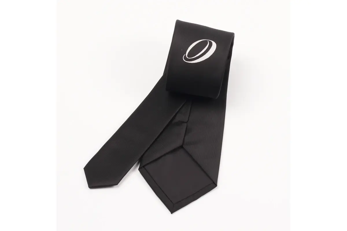 Black tie showing a pale letter O monogram and the reverse seam and tipping.