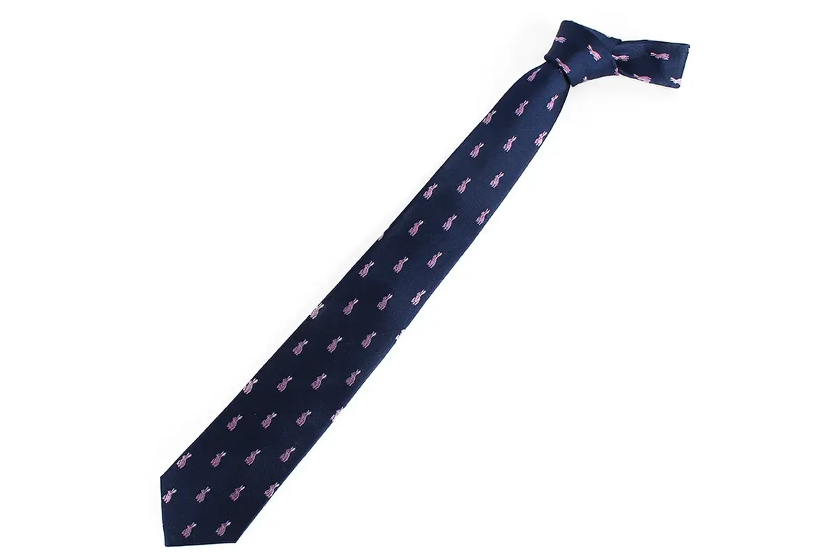 Knotted navy tie with small repeated pink motifs along the blade.