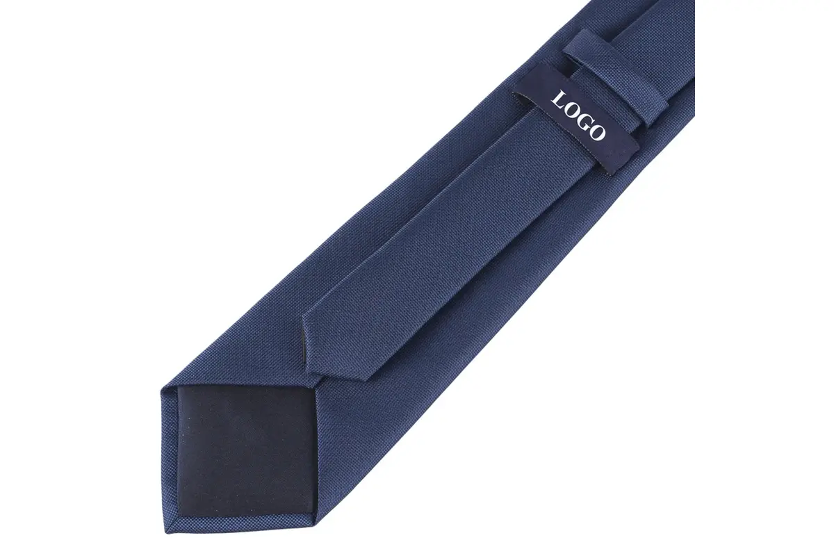 Navy tie reverse with a sample LOGO label, keeper loop and dark tipping.