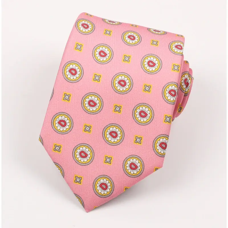 Rolled pink tie with multicolor circular emblems and small square motifs.
