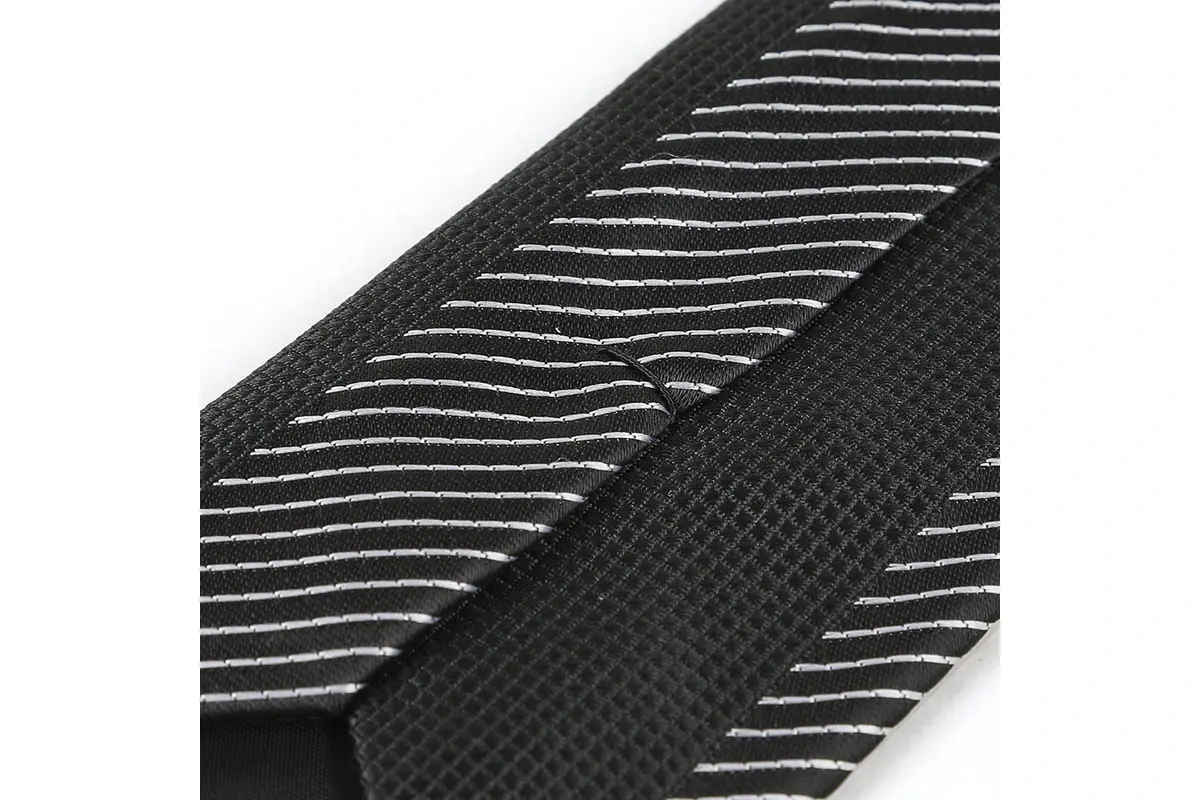 Close-up of a dark tie showing fine pale diagonal stripes and the reverse seam.