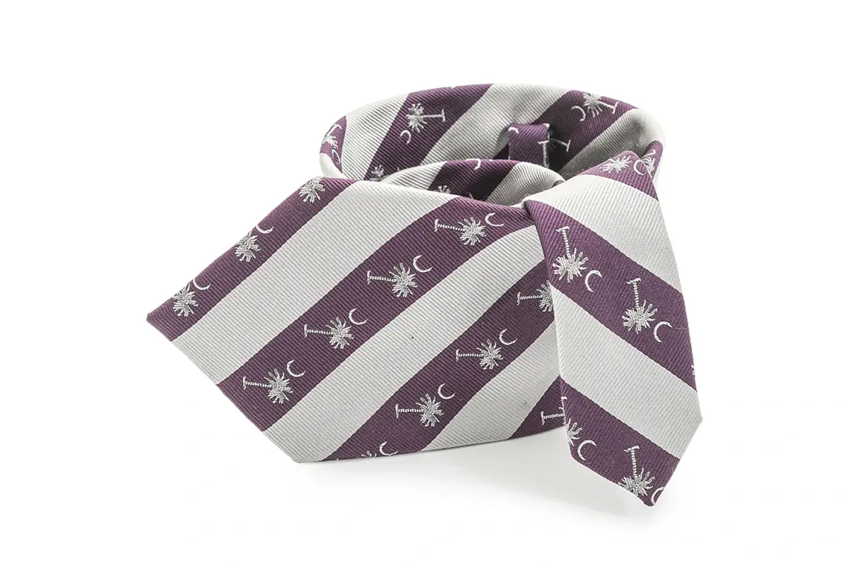 Purple and white striped tie with repeated pale palm-tree and crescent motifs.