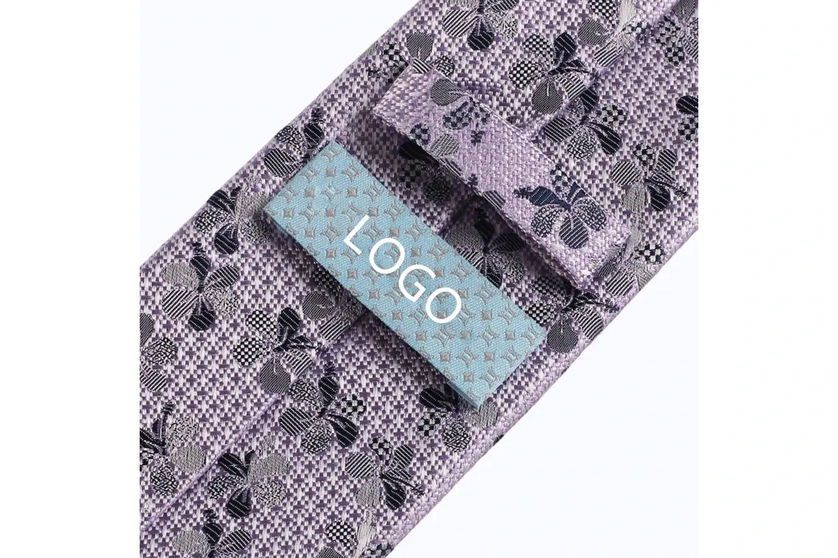 Pale blue sample logo label sewn onto the reverse of a lilac floral tie.