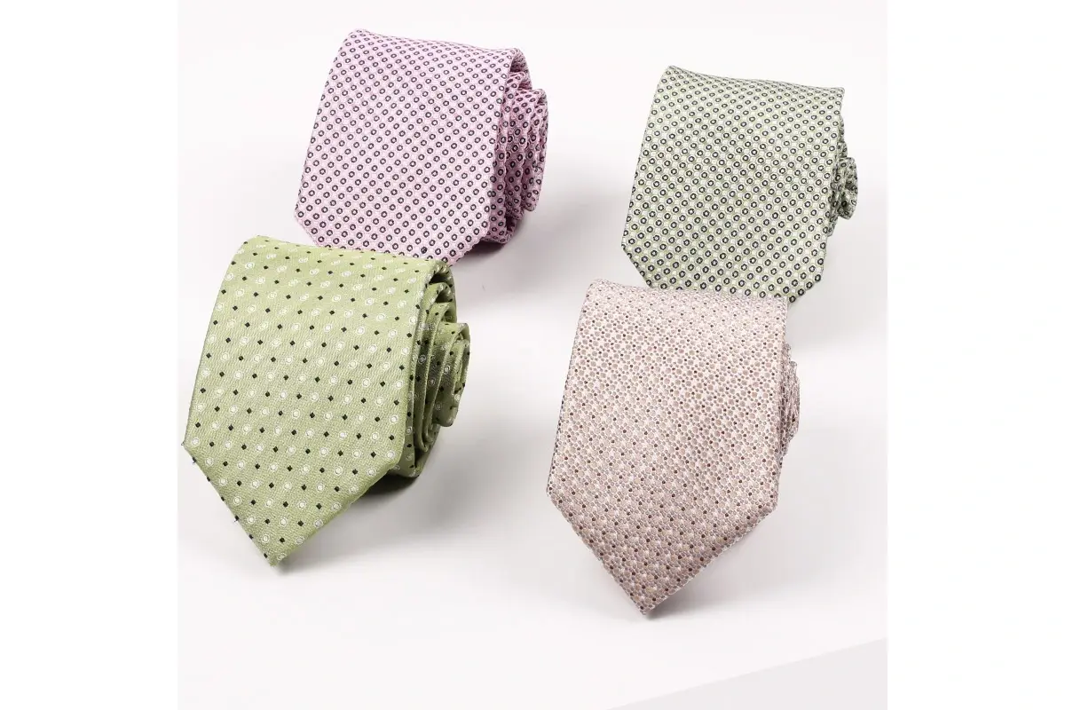 Four ties in pale pink and green with small repeating woven patterns.