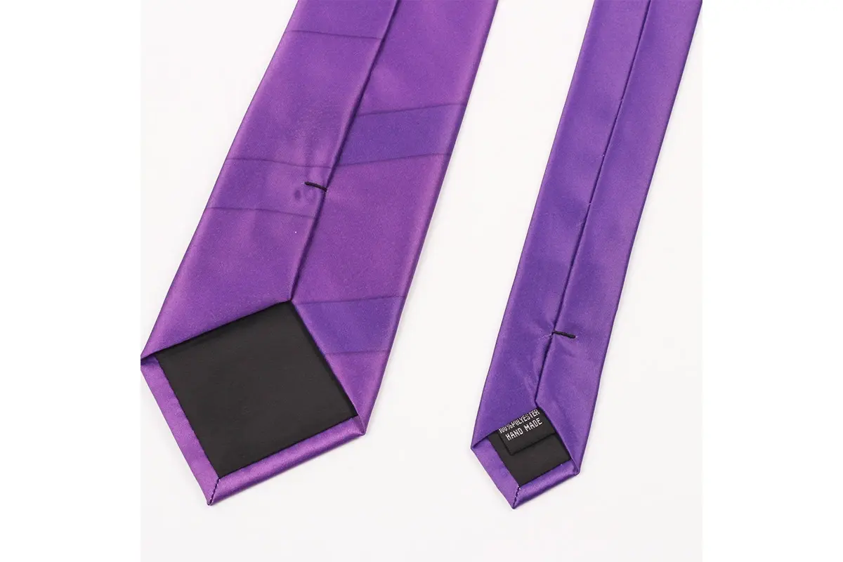 Reverse of a purple tie showing folded edges, a center seam and dark tipping.