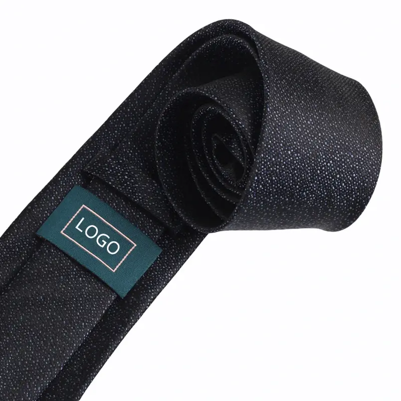 Rolled black tie showing a green sample logo label on the reverse.