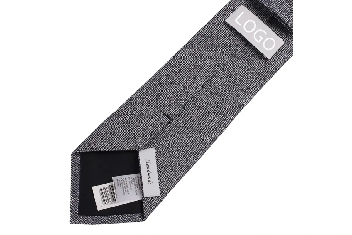 Grey tie reverse with a sample logo label, a Handmade label and a barcode tag.