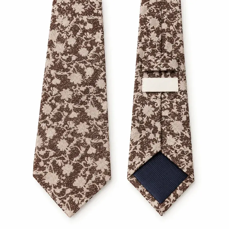 Ivory and brown botanical printed tie with dark tipping and a blank label.