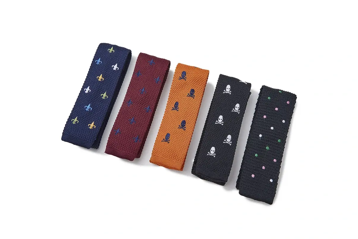 Five folded tie pieces in navy, burgundy, orange, black and green.
