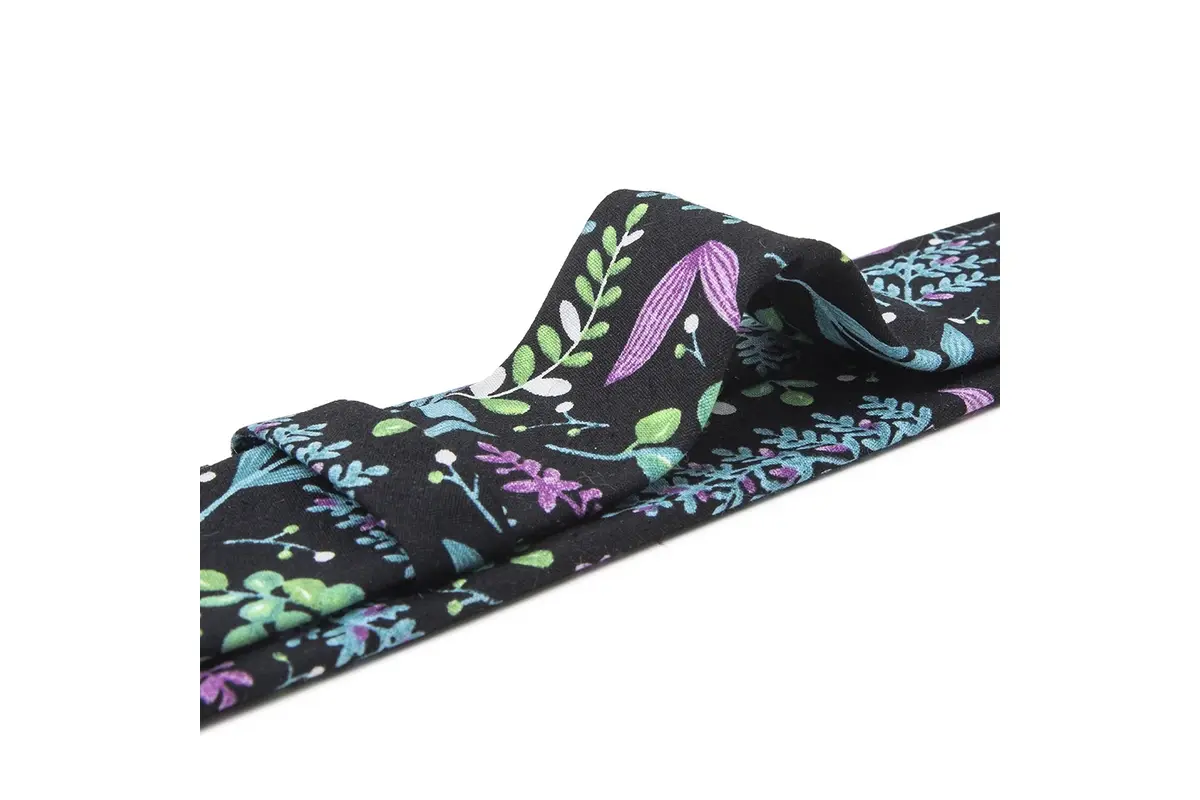 Navy printed tie with colorful floral motifs across its knot and folded blade.