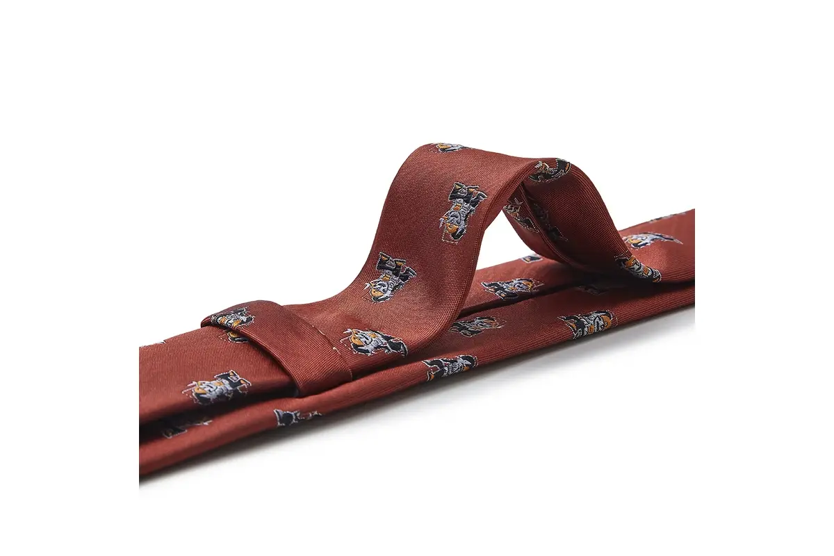 Rust-colored printed tie tied in a knot with small motifs crossing the folds.