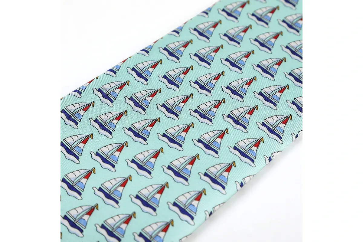 Close view of a light blue tie with regularly spaced sailboat motifs.
