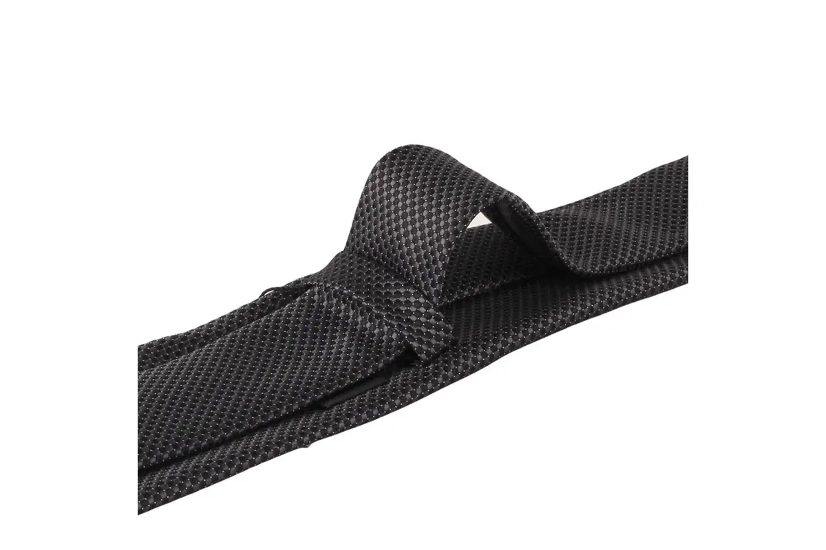 Close view of a black textured tie tied in a finished knot.